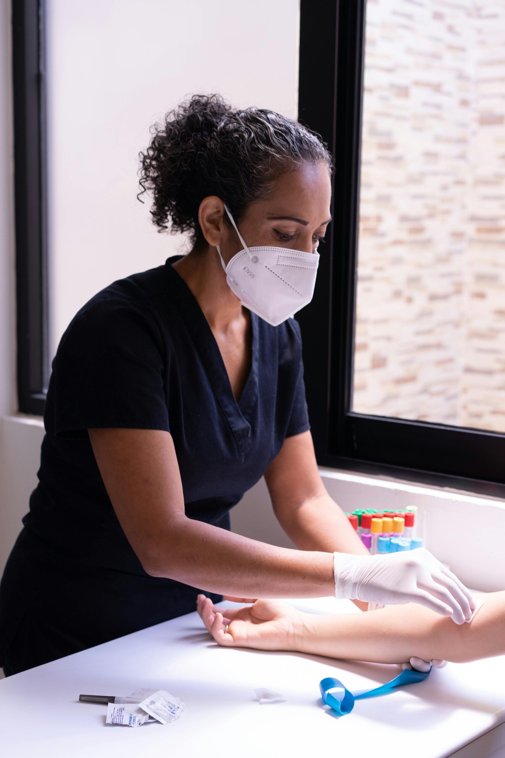 Professional nurse prepares a patient for a blood test in a medical clinic.